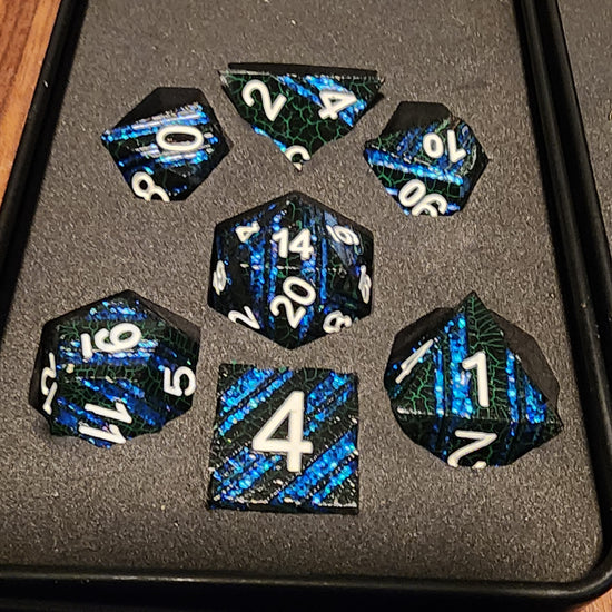 Deepforge black and blue striped seven-piece metal dice set in a padded box