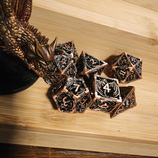 Copper hollow metal dragon dice beside a dragon figurine