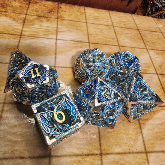 Silver and blue hollow metal dragon dice with gold-colored numbers