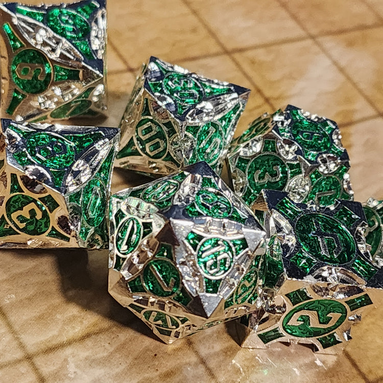 Silver and green seven-piece metal dice set with sculpted geometric details
