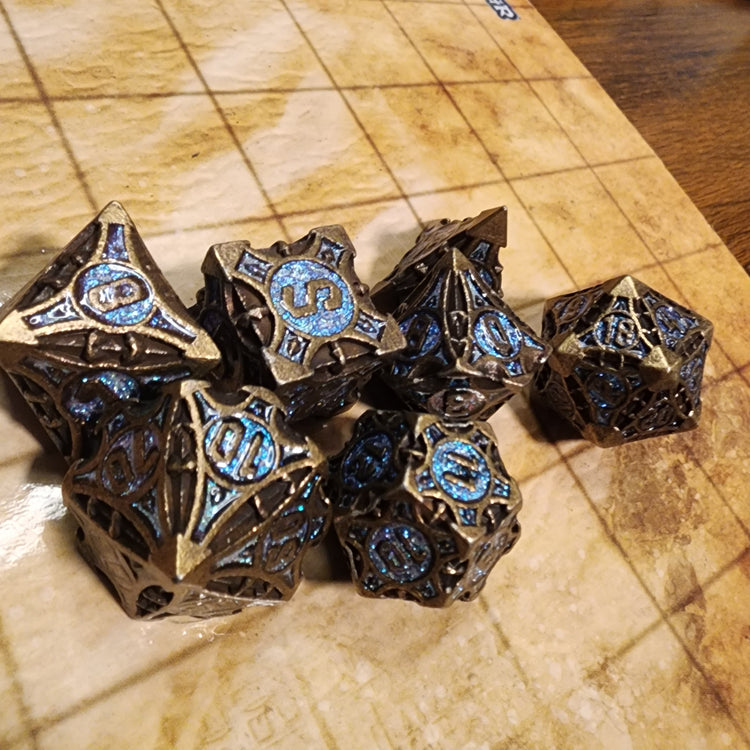 Antique bronze and light blue seven-piece metal dice set with sculpted geometric details