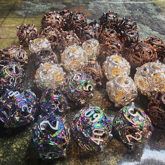 Group view of rainbow, silver and gold, black and orange, burned brass, and copper hollow metal dice