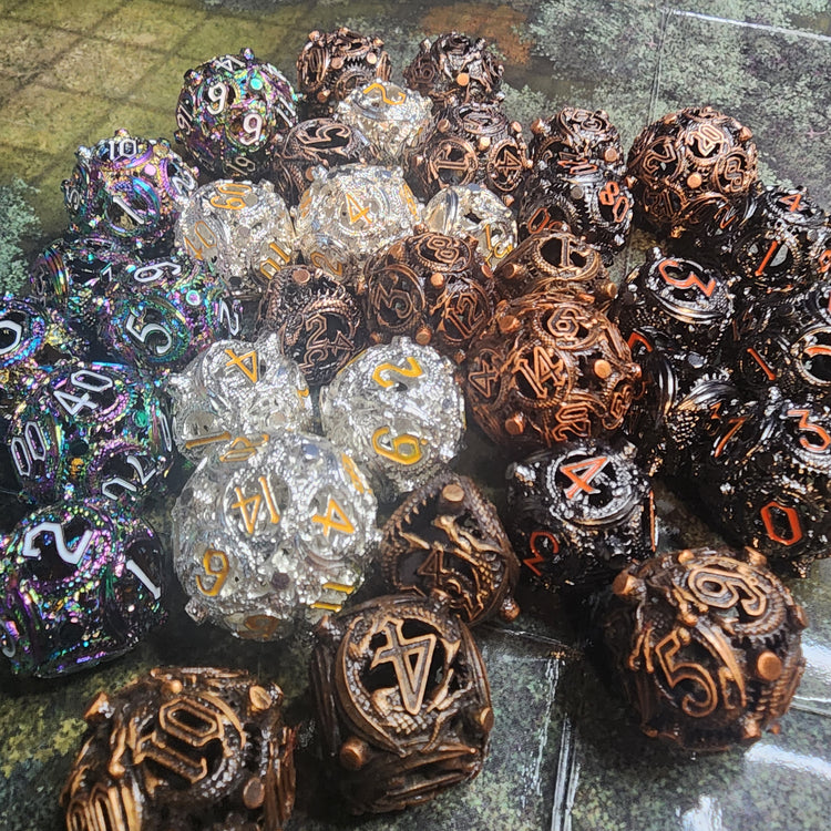 Five finishes of Wyrmseal Relics hollow metal dice with coiling scale-textured details