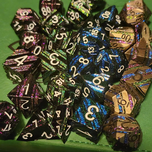 Dwarven Citadels striped metal dice in purple, green, blue, and gold rainbow finishes