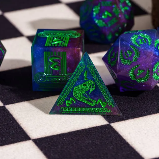Close-up of green serpent and classical column designs on Children of Medusa dice