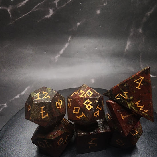 Dragonblood Jasper dice arranged on a black circular display