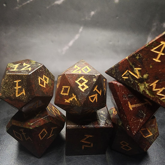 Close-up of Dragonblood Jasper dice with gold numbering on a black display