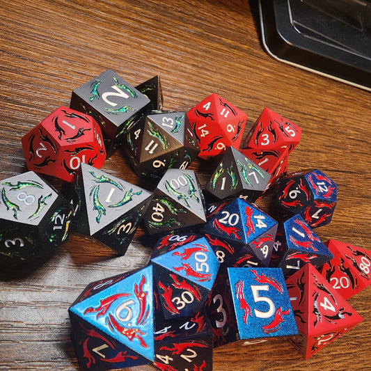 Three colors of dagger metal dice arranged on a wooden tabletop
