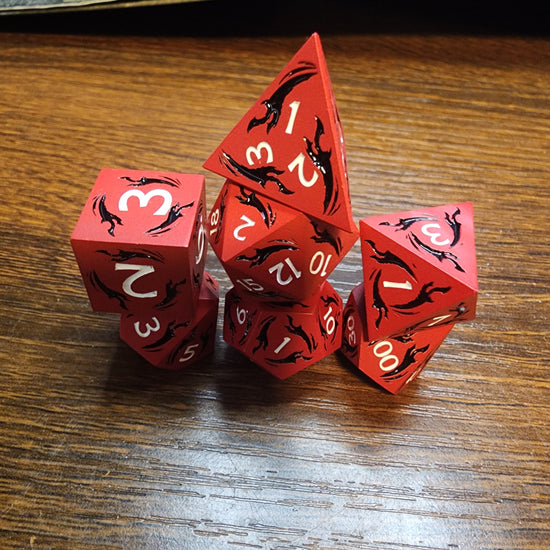 Red metal dice with black dagger motifs