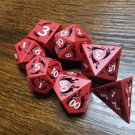 Red and black seven-piece dagger dice set on a wooden tabletop