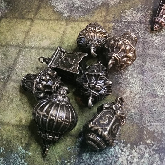 Seven-piece forest lantern metal dice set in brass finish