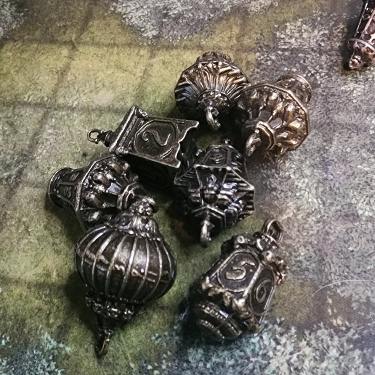 Seven-piece forest lantern metal dice set in brass finish