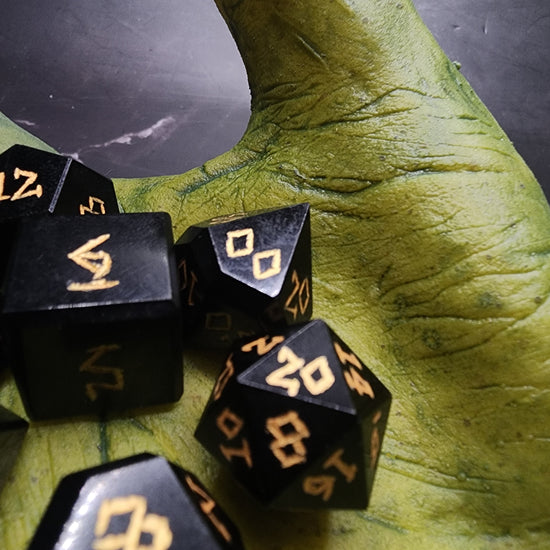 Close-up of black Obsidian dice and gold-colored numbering