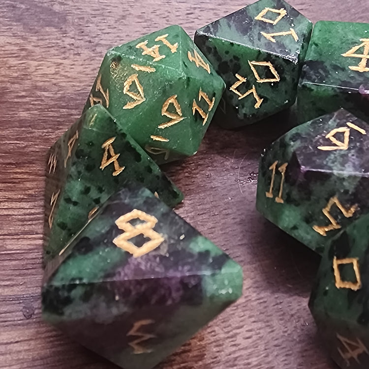 Close-up of Ruby Zoisite dice showing varied stone patterns and gold-colored numbering