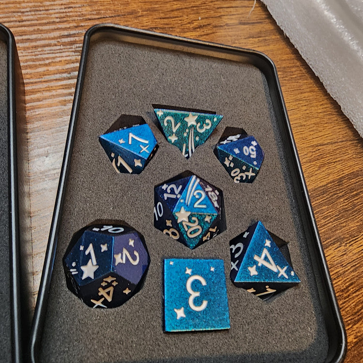 Blue and purple celestial seven-piece metal dice set in its tin