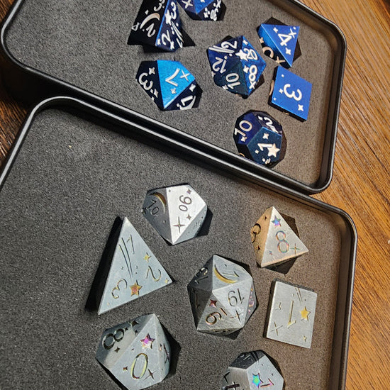 Angled view of silver and blue celestial metal dice sets in their tins
